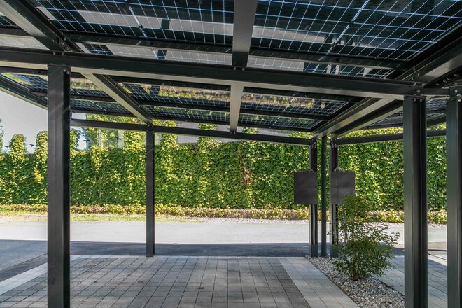 Modernes Carport mit integrierten Solarpanelen, das nachhaltige Energiegewinnung und praktischen Wetterschutz in stilvoller Umgebung vereint. Modernes Carport mit integrierten Solarpanelen, das nachhaltige Energiegewinnung und praktischen Wetterschutz in stilvoller Umgebung vereint.